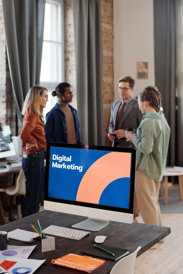 Services Business team engaged in a digital marketing discussion in a modern office setting.